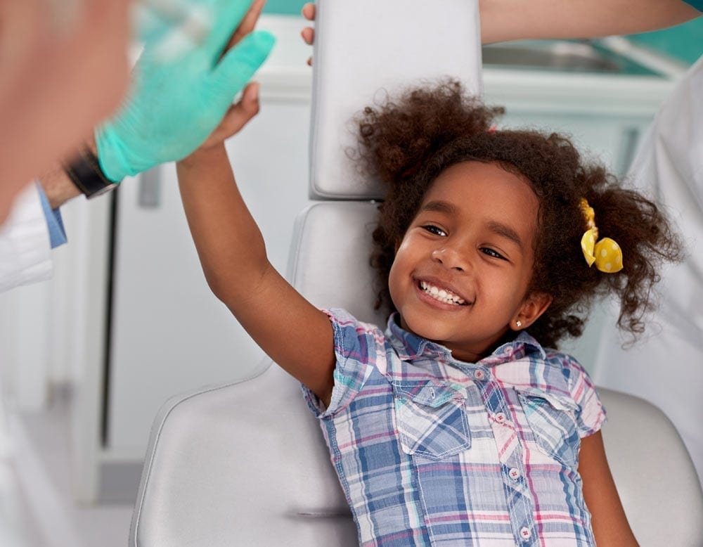Child Patient High-Fiving Dentist