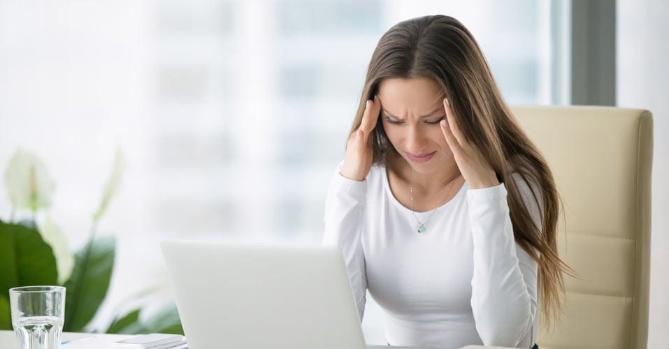 Woman with a headache, rubbing her temples