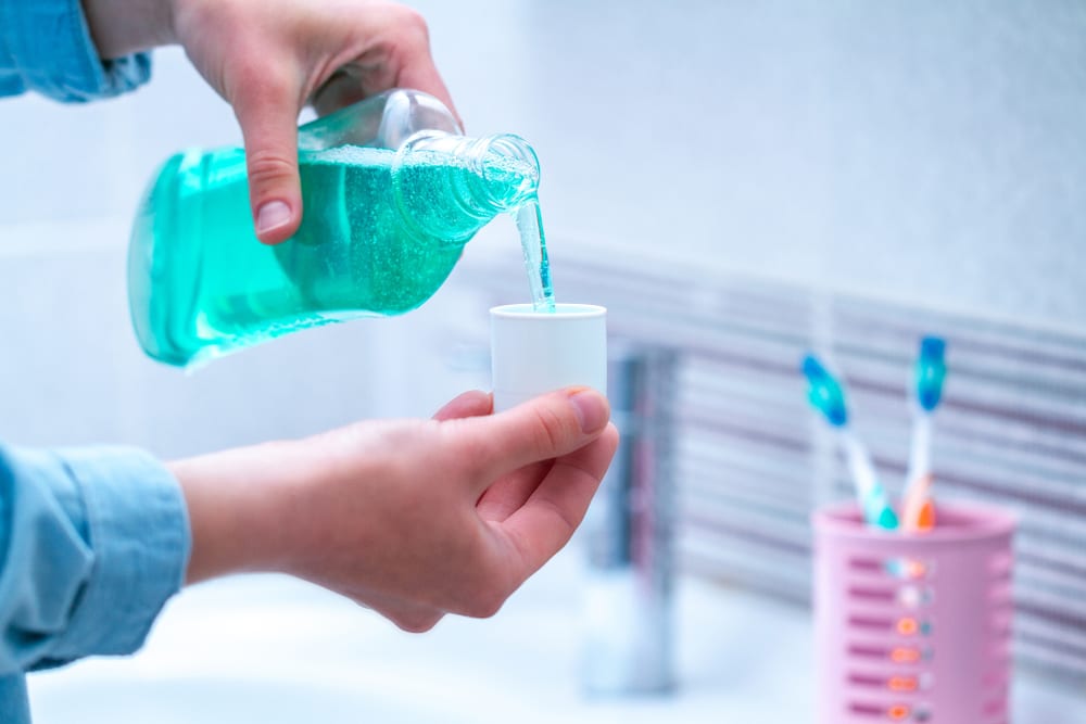 Man Pouring Mouthwash in Cup