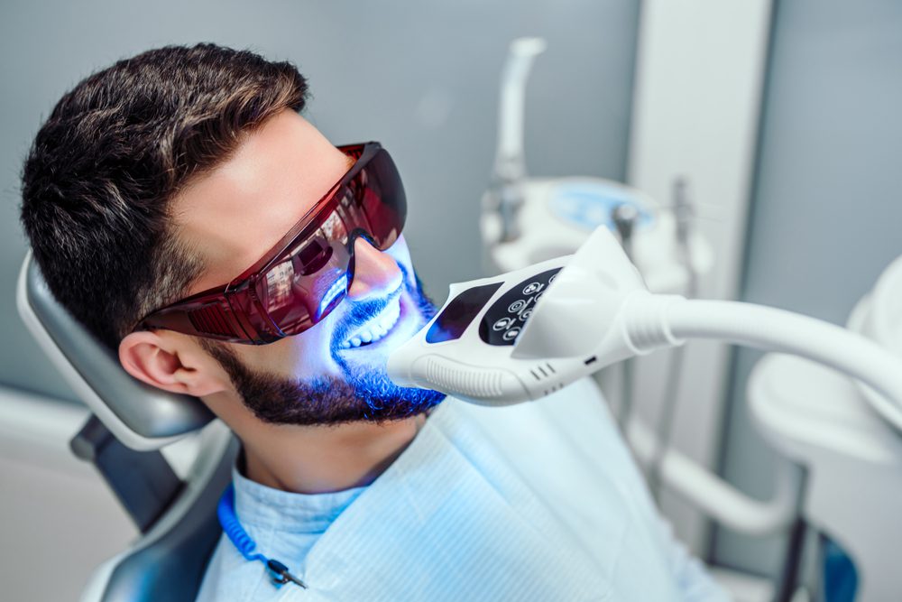Man Wearing Eye Protection Receiving Teeth Whitening Treatment